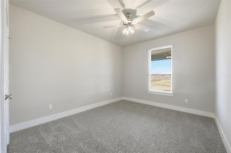 Unfurnished room featuring carpet flooring and a ceiling fan