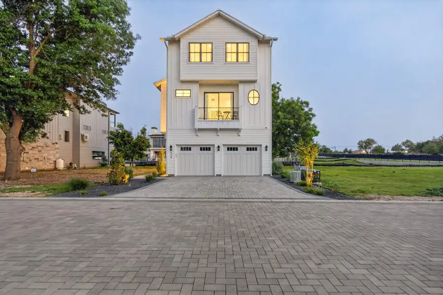 A striking modern facade with multiple levels, crisp white siding, and a paver driveway. A striking modern facade with multiple levels, crisp white siding, and a paver driveway.