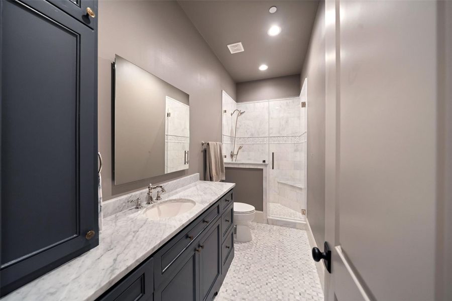En-suite bathroom features a walk-in shower with elegant marble floors.