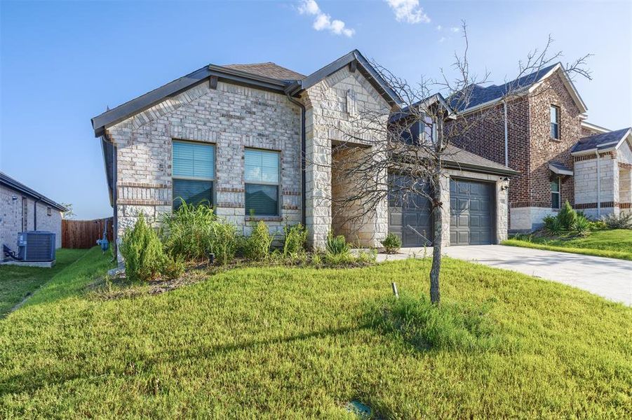 View of front facade with a garage, stone siding, and concrete driveway View of front facade with a garage, stone siding, and concrete driveway