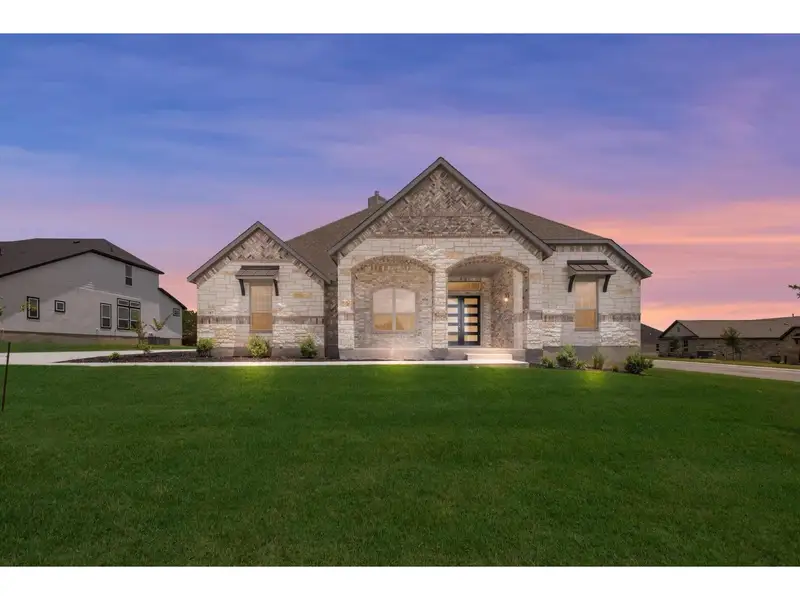 Front exterior of a new home in Potranco Oaks, Castroville, TX, highlighting curb appeal (Image 1).