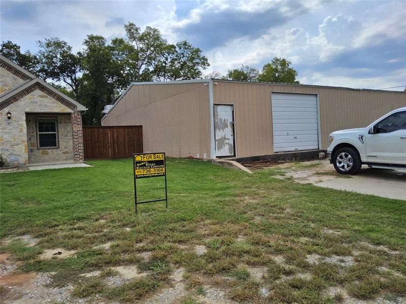 View of outdoor structure with a yard and a garage