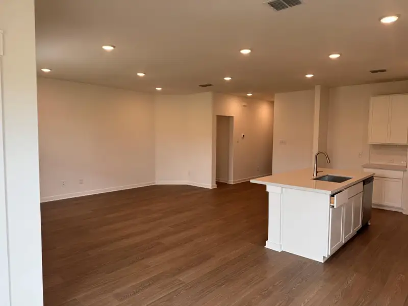 Kitchen featuring open floor plan, recessed lighting, white cabinetry, dark wood finished floors, and an island with sink Kitchen featuring open floor plan, recessed lighting, white cabinetry, dark wood finished floors, and an island with sink