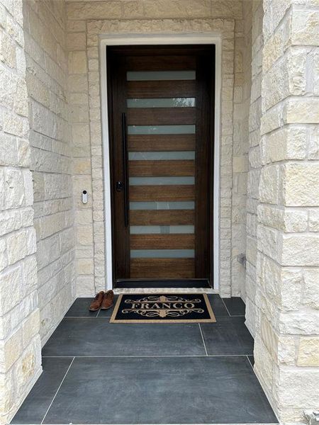Doorway to property featuring stone siding