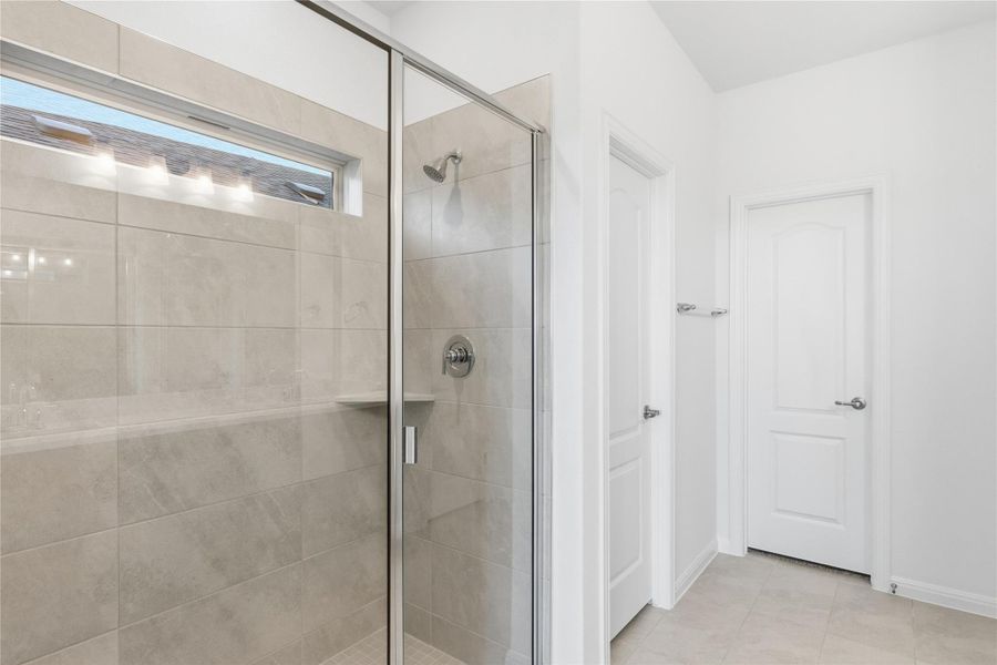 Bathroom featuring a stall shower and light tile patterned floors