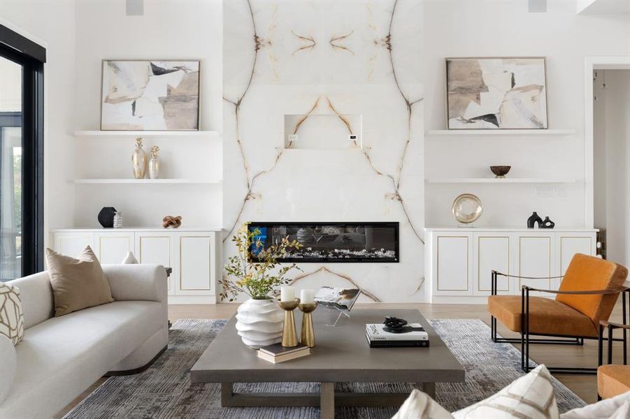 Indulge in luxury in your living room, featuring two story ceilings and a marble-clad fireplace that stretches from floor to ceiling, adding a touch of opulence to your space.