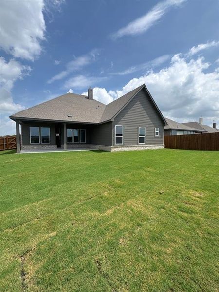 Expansive rear lawn with a privacy fence