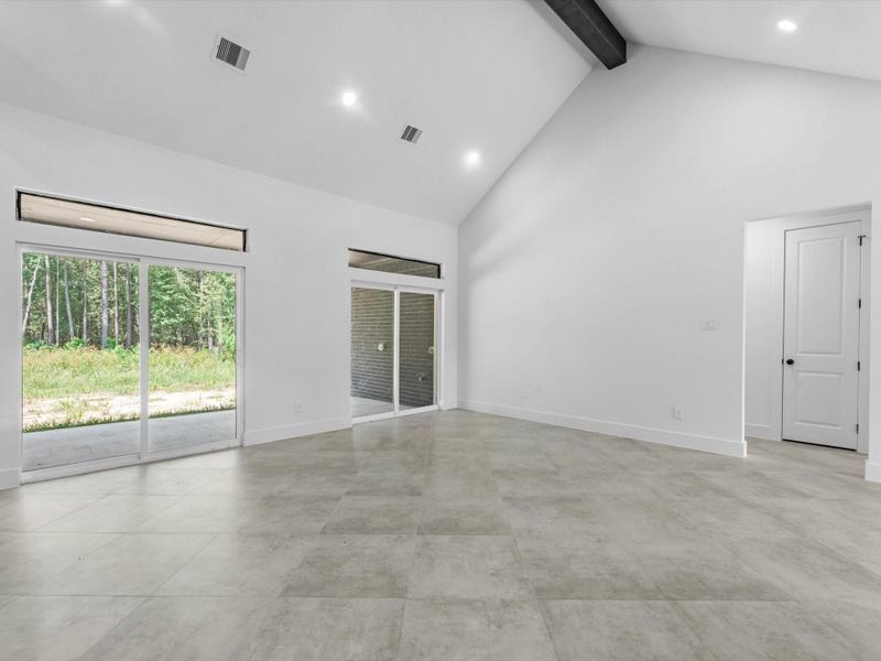 Another view of the living room with so much natural light and the gorgeous beam. High ceilings make the space feel grand.