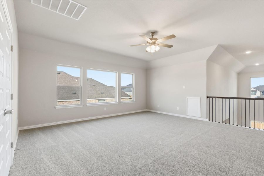 Unfurnished room featuring light colored carpet and a ceiling fan
