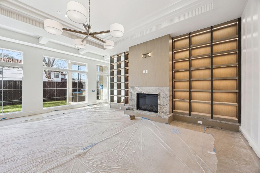 Family Room with a Direct Vent Fireplace and Built-in Shelves with White Oak back Panels. There is a stone hearth and stain grade panels the entire length of the wall.