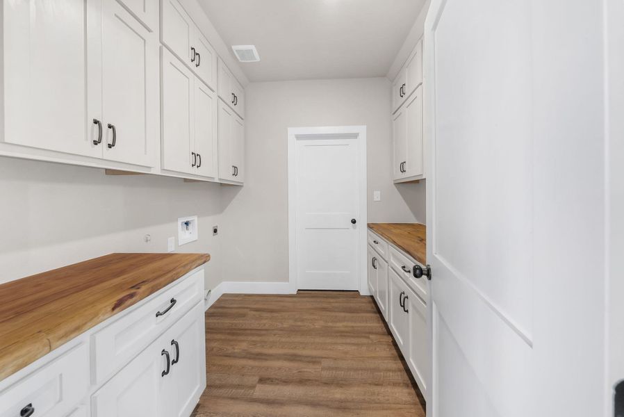 Laundry room with cabinet space, hookup for a washing machine, dark wood finished floors, and electric dryer hookup