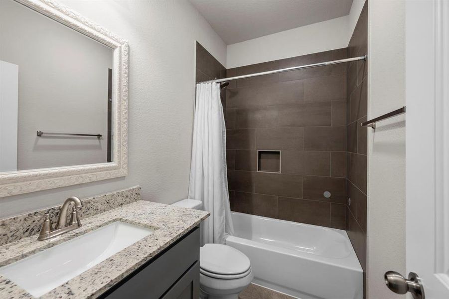 Large secondary bath features gorgeous granite and a tile surround tub/shower combo.