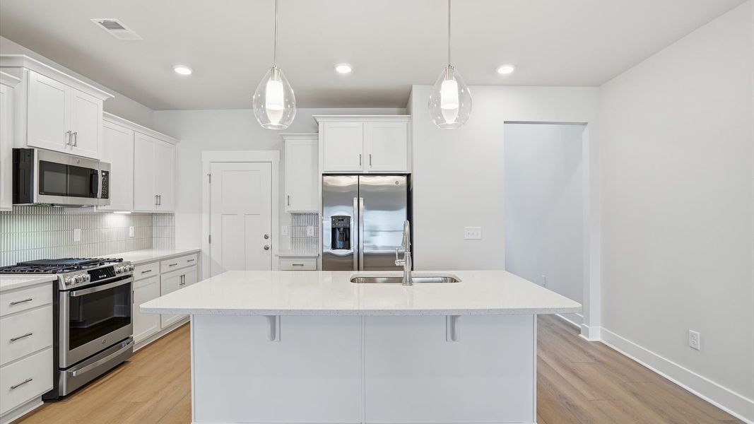 Open-concept kitchen designed to maximize both efficiency and entertaining potential at Village at Midway