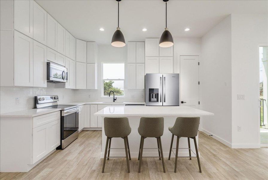 Open kitchen with stainless steel appliances and quartz counters. Open kitchen with stainless steel appliances and quartz counters.
