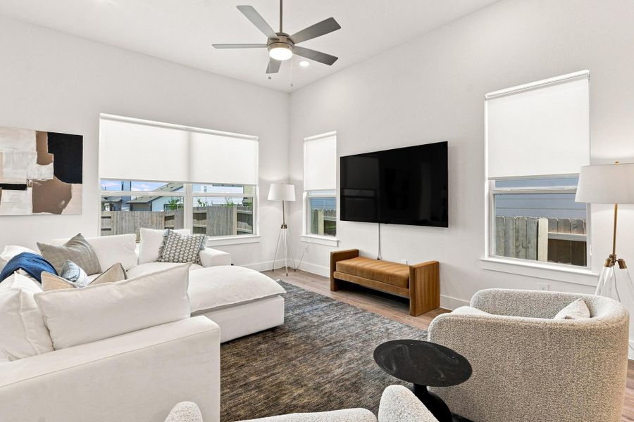 Family room retreat with custom ceiling fan, recessed lighting, and large windows bringing in abundant natural light. Family room retreat with custom ceiling fan, recessed lighting, and large windows bringing in abundant natural light.