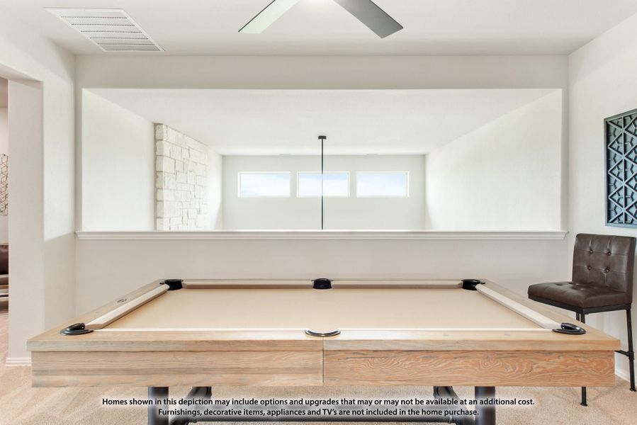 Game room with a wood-framed pool table, large wall mirror, and ceiling fan in a bright white space.