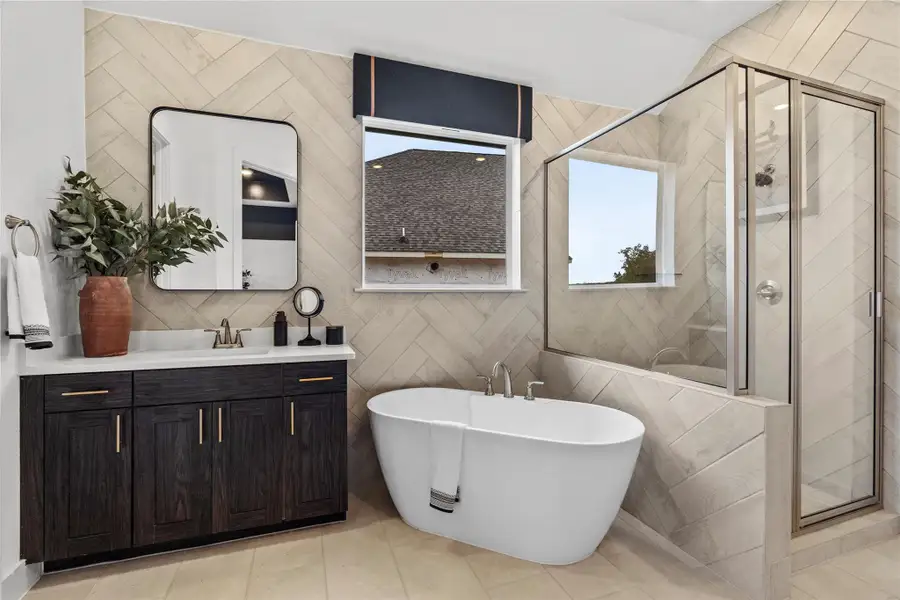 Bathroom featuring a shower stall, a soaking tub, and vanity