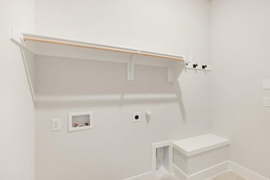 Laundry room with white upper shelf, hanging rod, washer hookups, and a small built-in bench with pet door.