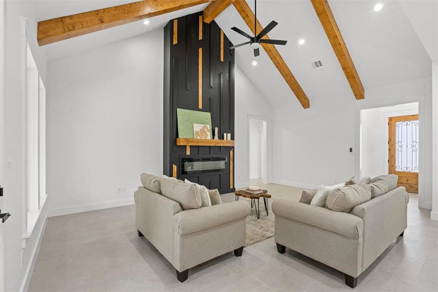 Living area featuring beam ceiling, a fireplace, recessed lighting, visible vents, and high vaulted ceiling