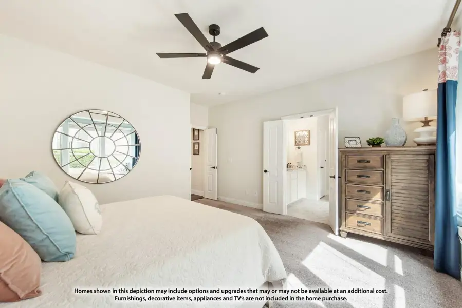 Bedroom with ceiling fan, carpet flooring, dresser, and open door to ensuite bathroom