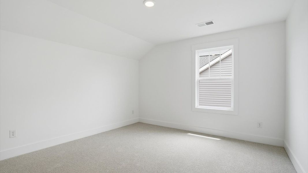 Notable secondary bedroom offering cozy carpeted flooring and a stylish walk-in closet