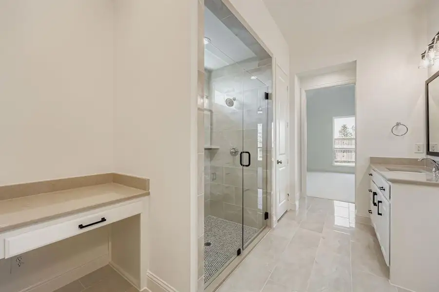 Bathroom with light tile patterned flooring, vanity, and a shower stall