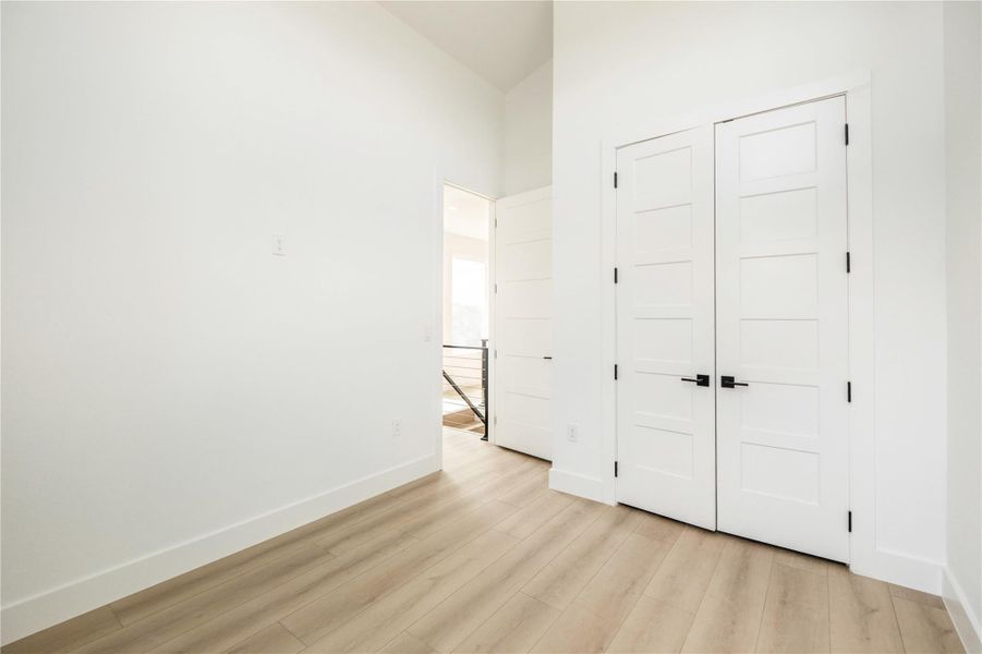 Unfurnished bedroom with light wood-style floors and a closet