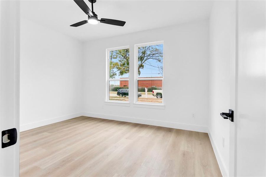 Empty room with light wood-style floors and ceiling fan