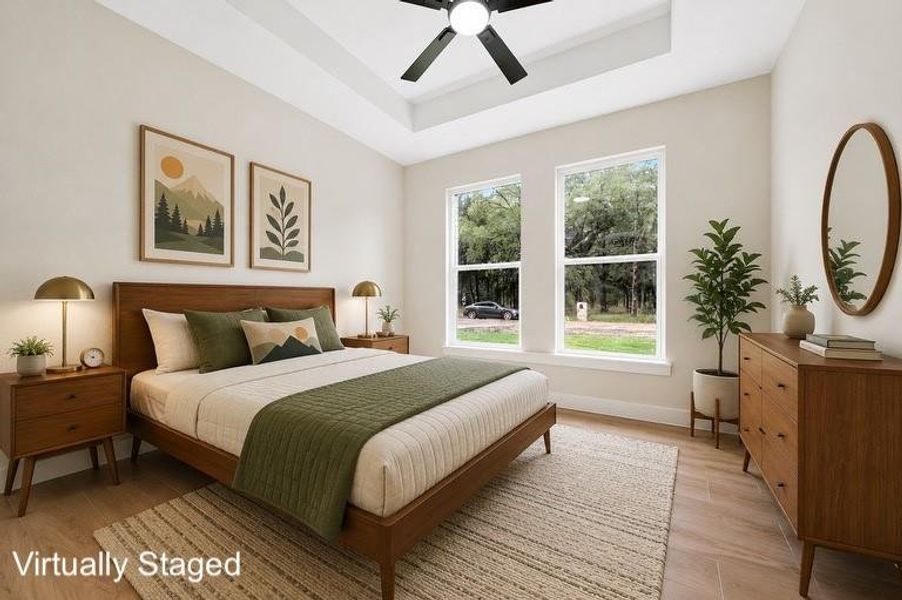 Spacious bedroom featuring light-colored walls and wood-finish flooring Spacious bedroom featuring light-colored walls and wood-finish flooring