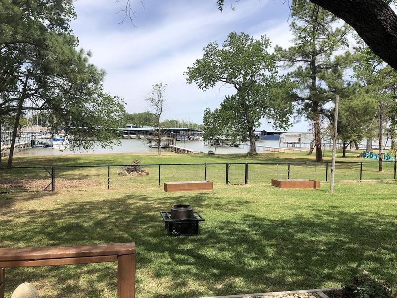 View of property's community featuring a water view, fence, and a lawn