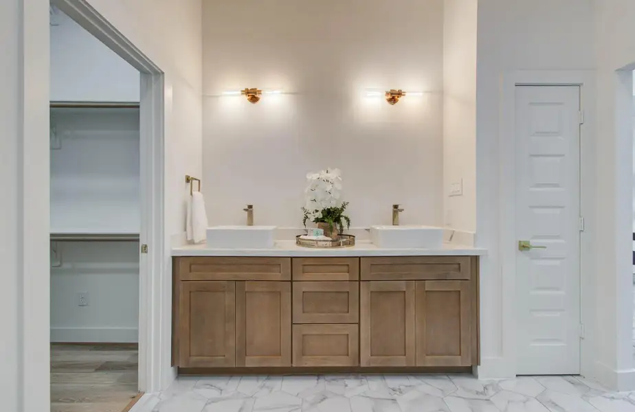 Dual vanities in natural wood adds warmth. Vessels sinks are modern and sleek.