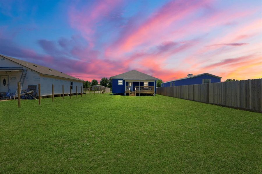 Spacious backyard bordered by a wooden fence, perfect for outdoor activities.