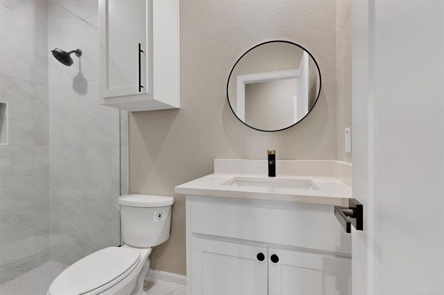 Full bath with vanity, a textured wall, and a tile shower Full bath with vanity, a textured wall, and a tile shower