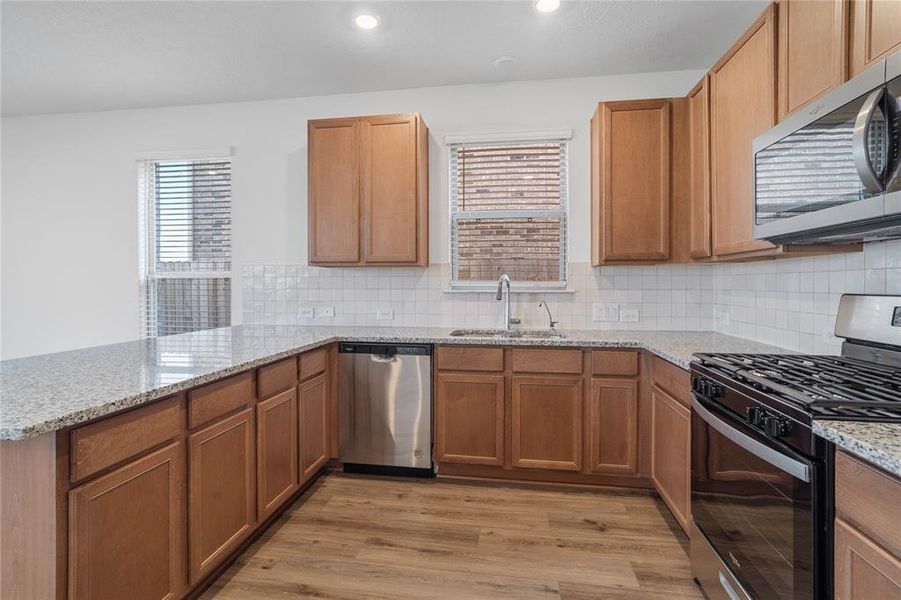 This kitchen is by far any chef’s dream! This spacious kitchen features high ceilings, stained wood cabinets, granite countertops, SS appliances, modern tile backsplash, recessed lighting, and extended counter for breakfast bar, and a pantry all overlooking your huge family room.