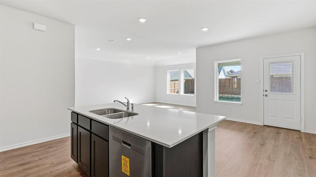 Kitchen with a kitchen island with sink, dishwasher, light wood-style floors, open floor plan, and recessed lighting Kitchen with a kitchen island with sink, dishwasher, light wood-style floors, open floor plan, and recessed lighting