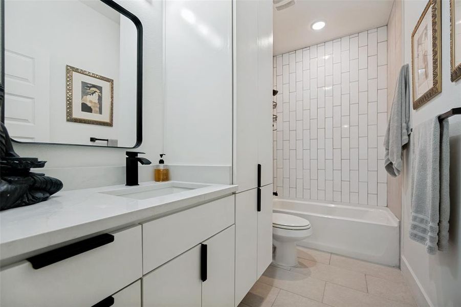 Contemporary bathroom featuring a white vanity with integrated sink, black matte fixtures, and a framed mirror Contemporary bathroom featuring a white vanity with integrated sink, black matte fixtures, and a framed mirror
