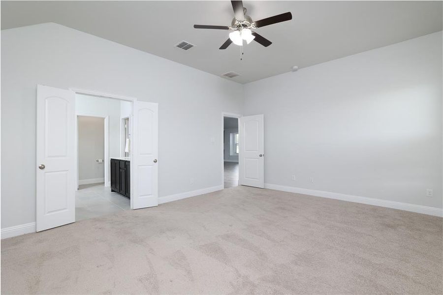 Unfurnished bedroom with light carpet and a ceiling fan