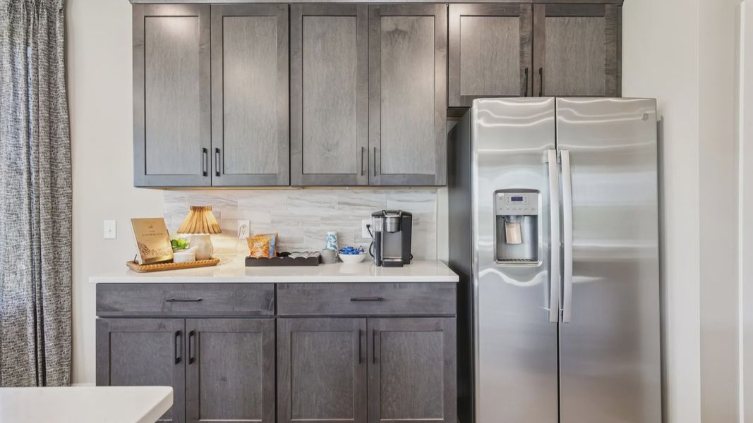 Kitchen with quartz countertops and dark cabinetry