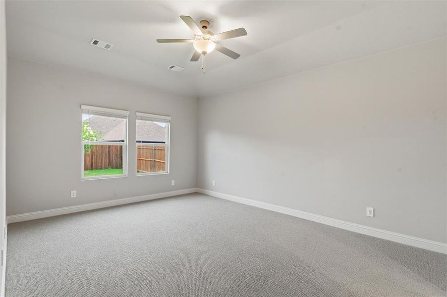 Spacious room with light gray carpeting, neutral wall color, and two windows providing natural light