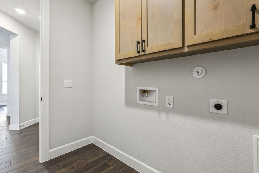 Washroom with dark wood-type flooring, cabinet space, and hookup for a washing machine Washroom with dark wood-type flooring, cabinet space, and hookup for a washing machine