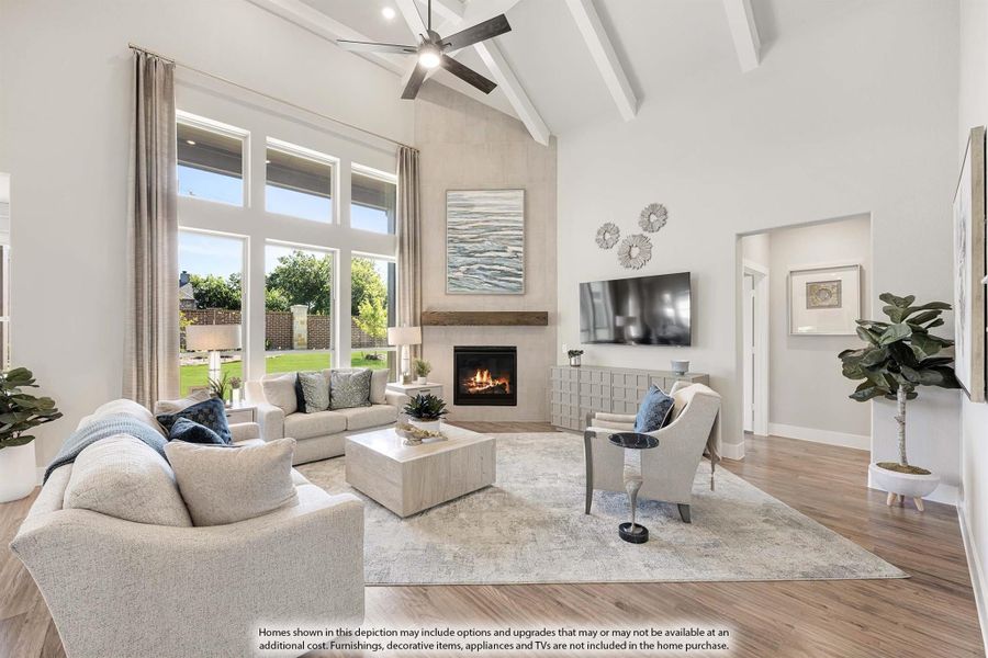 Bright living room with vaulted beamed ceiling, fireplace, hardwood floors, and large windows overlooking backyard