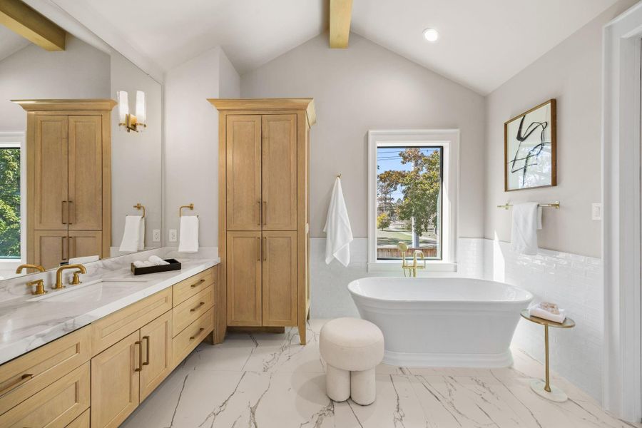 Primary Bath offers dual vanities, Soak tub, separate walk-in shower, white oak custom built linen storage & a massive walk-in closet. This spa-like retreat offers a quiet and elegant space for the Homeowners to collect themselves.