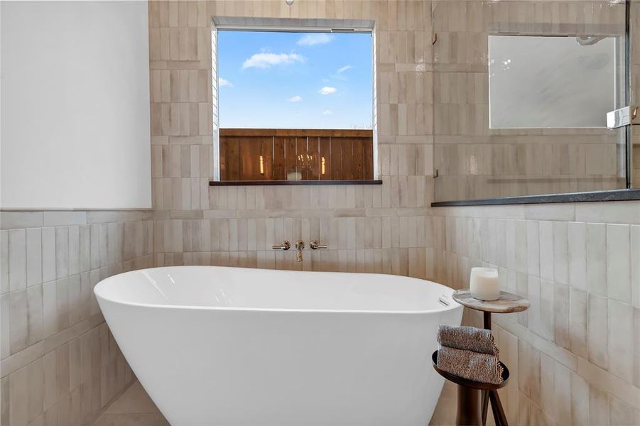 Full bath with a soaking tub and tile walls Full bath with a soaking tub and tile walls