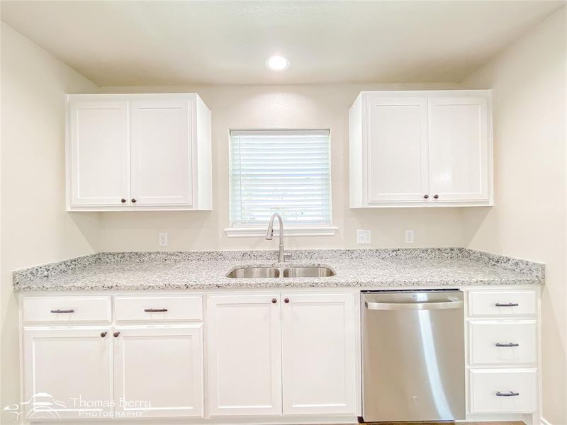 Kitchen featuring white cabinetry, dishwasher, light stone counters, and recessed lighting Kitchen featuring white cabinetry, dishwasher, light stone counters, and recessed lighting