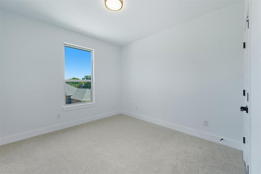 Unfurnished room with light colored carpet and baseboards