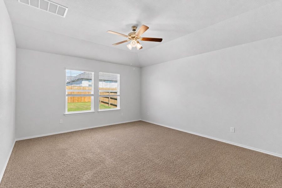 A spacious bedroom featuring carpeted flooring and abundant natural light from multiple windows, perfect for relaxation. A spacious bedroom featuring carpeted flooring and abundant natural light from multiple windows, perfect for relaxation.