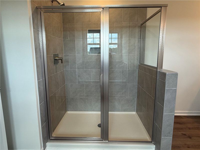 A sleek, tiled shower with glass doors and a neutr A sleek, tiled shower with glass doors and a neutr