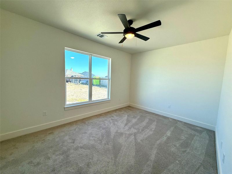 Carpeted spare room featuring baseboards and ceiling fan