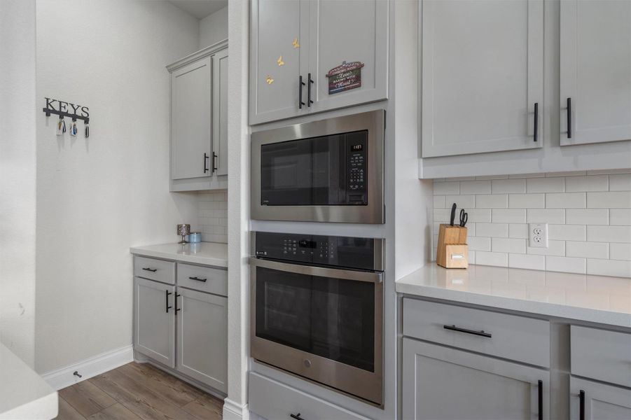 Sleek built-in appliances integrate seamlessly with shaker cabinetry and stone countertops.