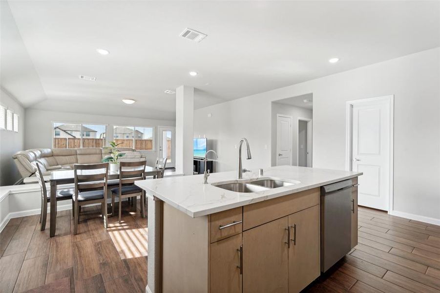 Kitchen featuring a kitchen island with sink, sink, stainless steel dishwasher, and dark hardwood / wood-style floors